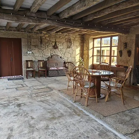 Sala interior da Casinha com paredes em pedra à vista e mesa de jantar