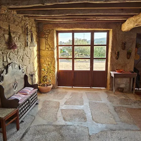 Terraço coberto em pedra com vista desafogada para o campo minhoto